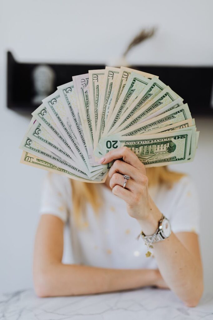 person holding fan of us dollar bills